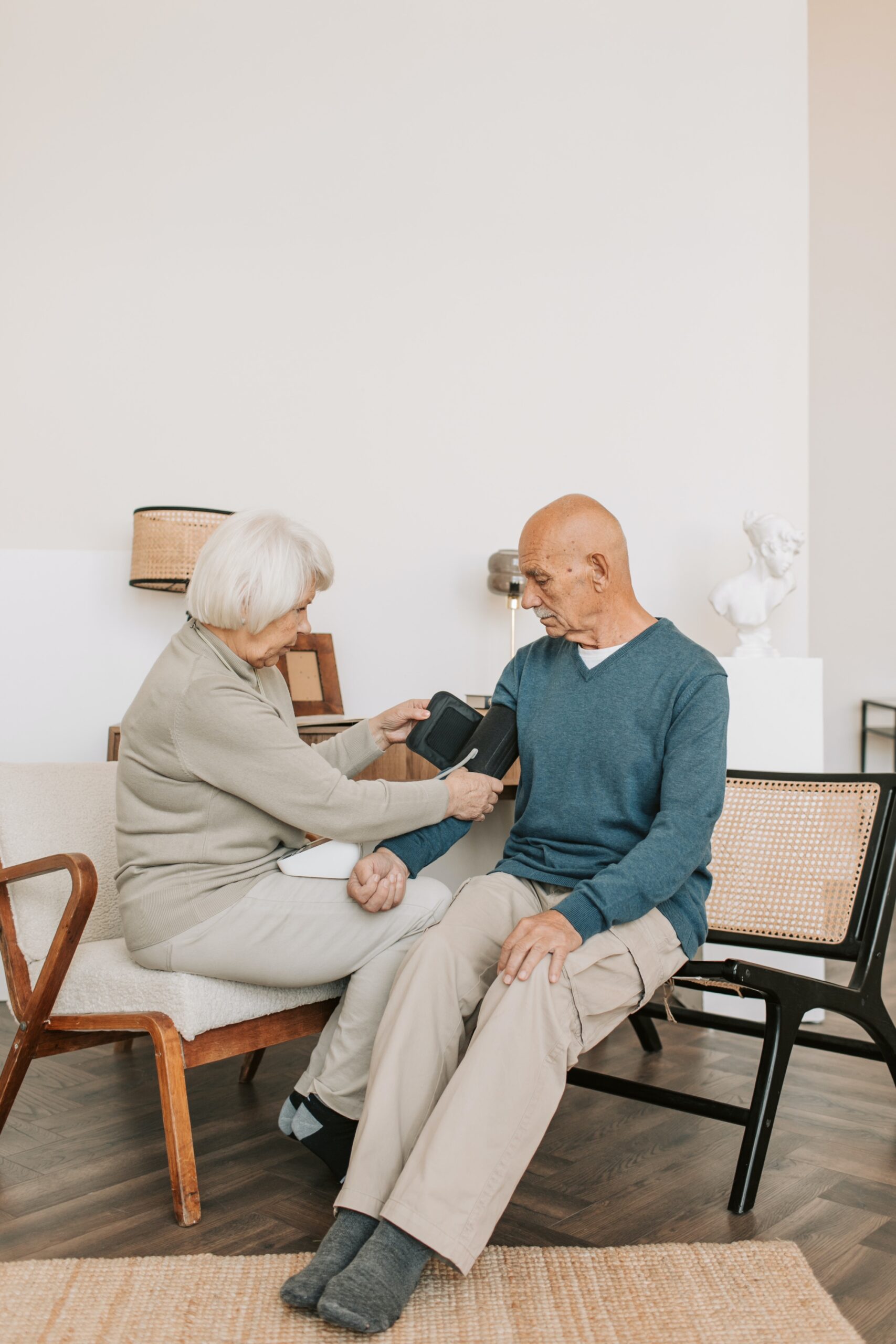 woman checking elderly patient`s blood pressure
